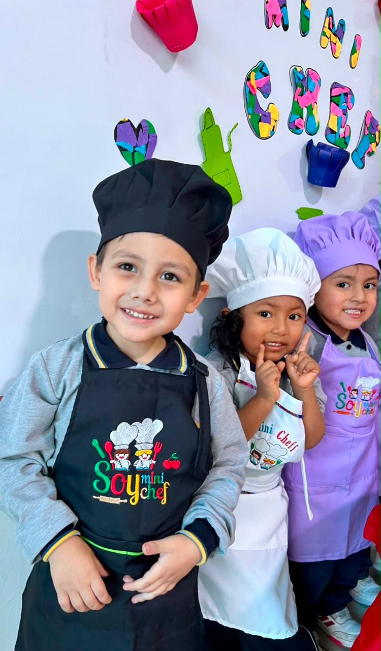 Niños de inicial vestidos de mini chef durante un taller de cocina